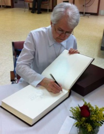 La prieure générale, soeur Raymonde Dussault, signe le Livre d'or des fêtes du 350e anniversaire de fondation du Séminaire de Québec (Photo H. Giguère)